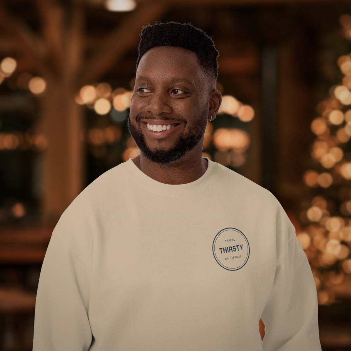 Man wearing the Brewery Passport Crewneck Sweatshirt in Bone with holiday lights