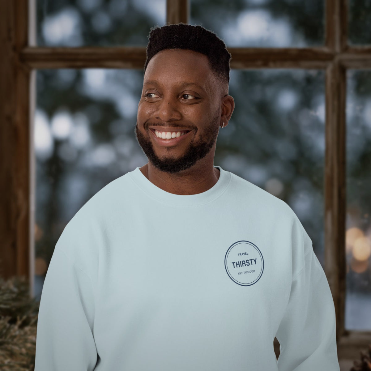 Man wearing the Brewery Passport Crewneck Sweatshirt in Sky Blue by a winter window