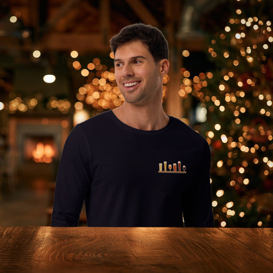 Smiling man in the navy Christmas Flight 2026 long sleeve tee at a holiday taproom with a lit Christmas tree
