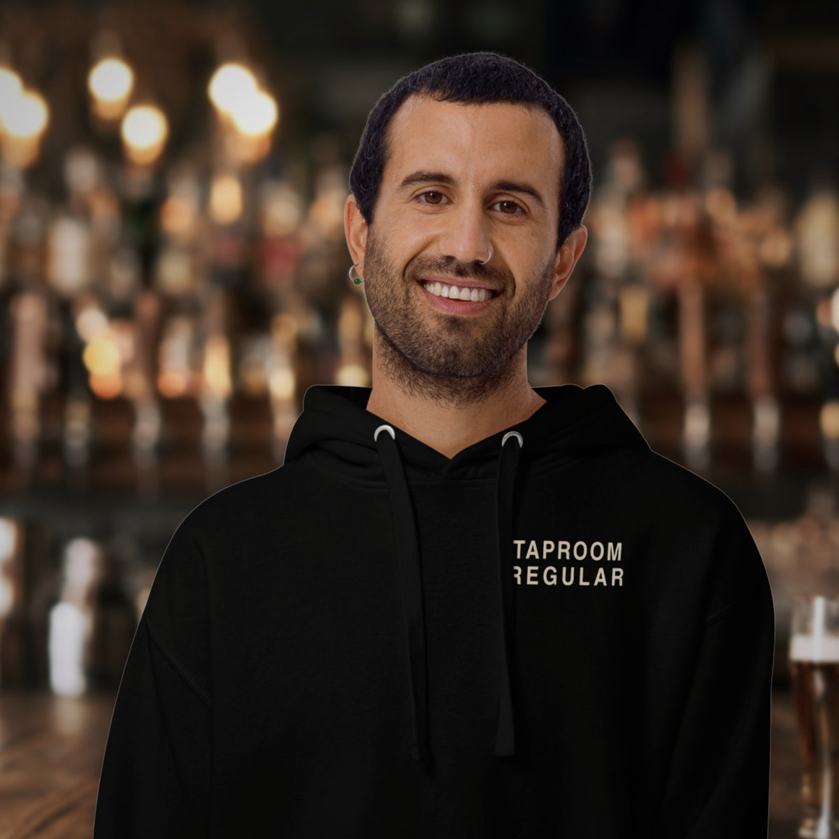 Man wearing the Taproom Regular Hoodie in Black at the bar
