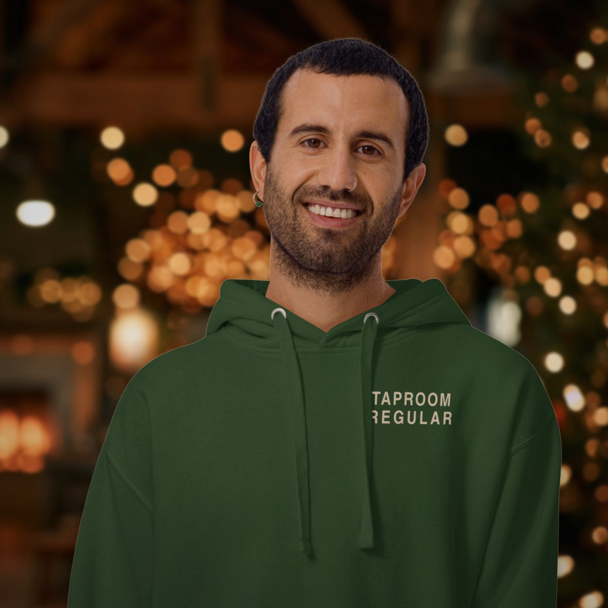 Man wearing the Taproom Regular Hoodie in Forest Green with holiday lights