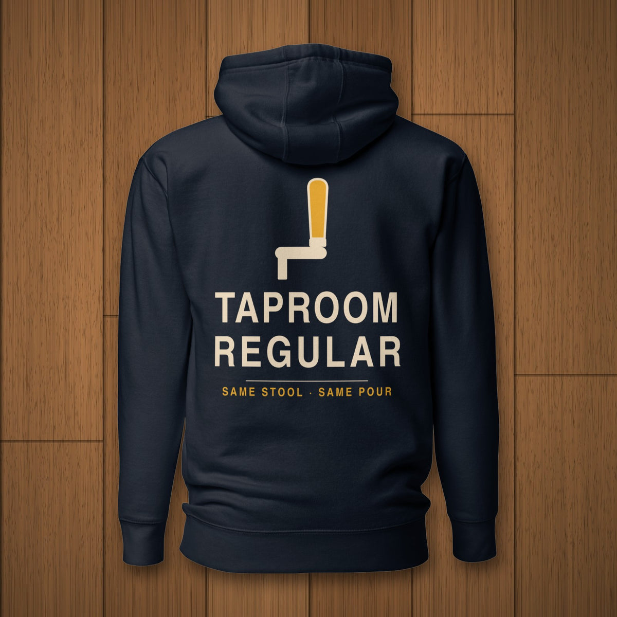 Back of the Taproom Regular Hoodie in navy with the tap handle and Same Stool Same Pour design on oak boards